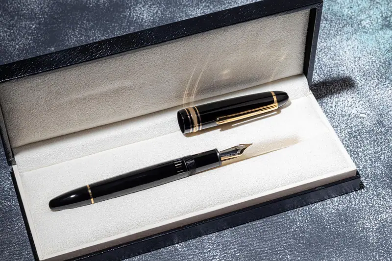 Stylo-plume noir et doré posé dans un coffret ouvert à intérieur blanc